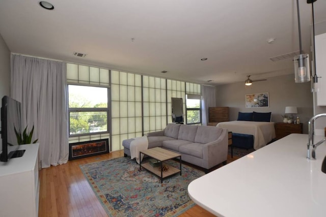 6000 S Congress Ave Unit 132, Austin, TX 78745 - living room with light wood-style floors, ceiling fan, and a fireplace