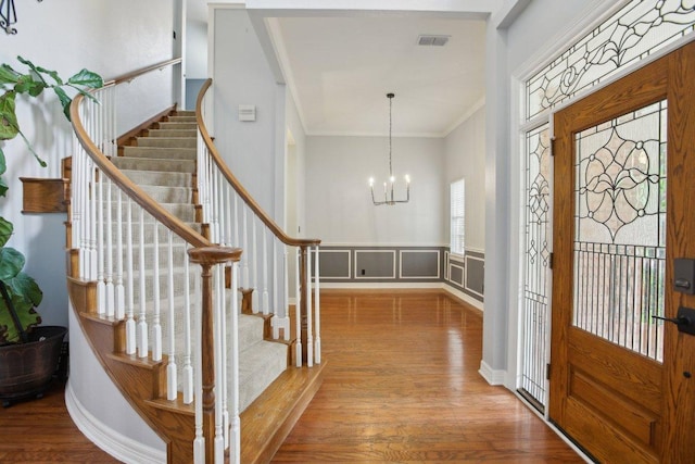 30418 La Quinta Dr, Georgetown, TX 78628 - entryway featuring ornamental molding, wood finished floors, stairs, a chandelier, and a wainscoted wall