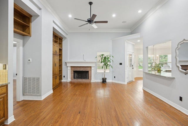 30418 La Quinta Dr, Georgetown, TX 78628 - unfurnished living room featuring ceiling fan, a brick fireplace, light wood-style floors, ornamental molding, and recessed lighting