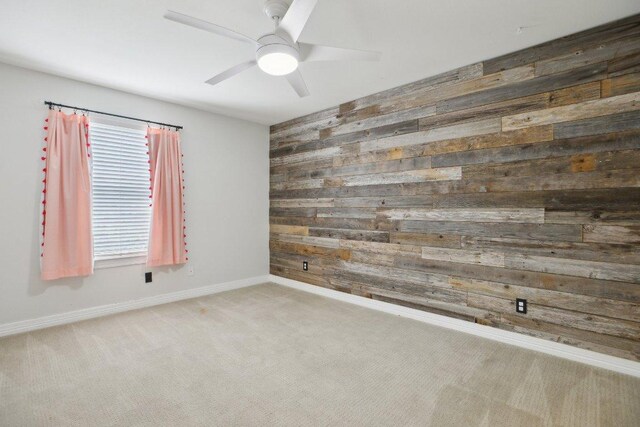 30418 La Quinta Dr, Georgetown, TX 78628 - carpeted spare room featuring wood walls, a ceiling fan, and baseboards