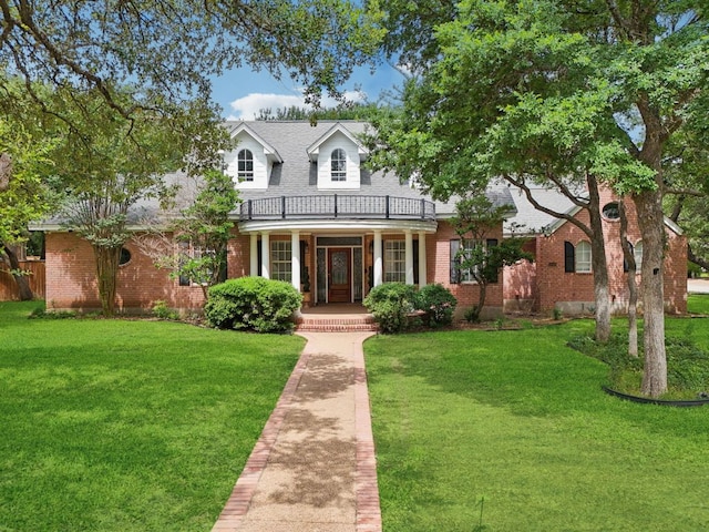 30418 La Quinta Dr, Georgetown, TX 78628 - cape cod house featuring brick siding, a porch, a front lawn, a balcony, and roof with shingles