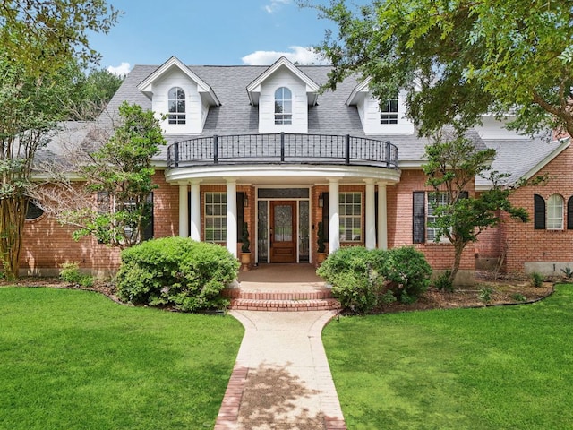 30418 La Quinta Dr, Georgetown, TX 78628 - view of front of home with a balcony, covered porch, brick siding, and a front lawn