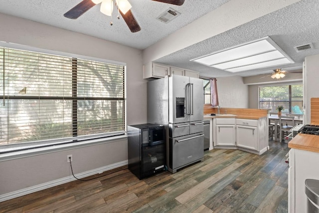 811 Timber Trl, Cedar Park, TX 78613 - kitchen featuring ceiling fan, stainless steel appliances, butcher block countertops, a peninsula, and a textured ceiling