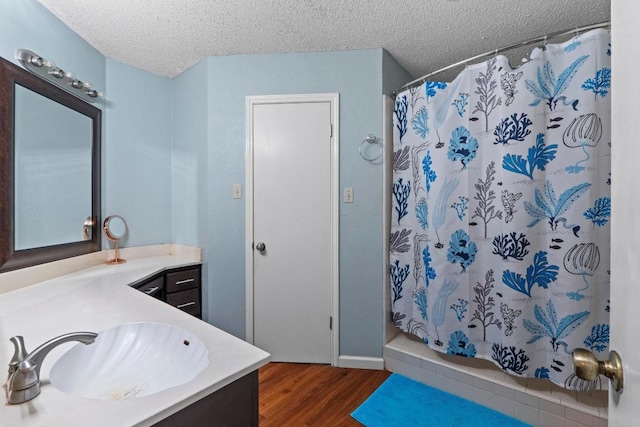 811 Timber Trl, Cedar Park, TX 78613 - full bathroom featuring vanity, wood finished floors, a shower with curtain, a textured ceiling, and baseboards