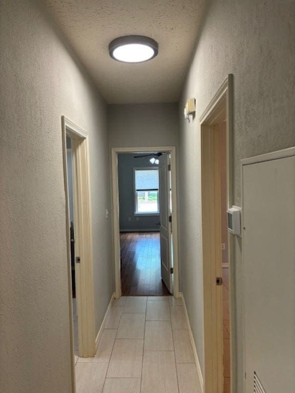 307 Quarry St, San Marcos, TX 78666 - corridor featuring a textured wall, a textured ceiling, and light tile patterned floors
