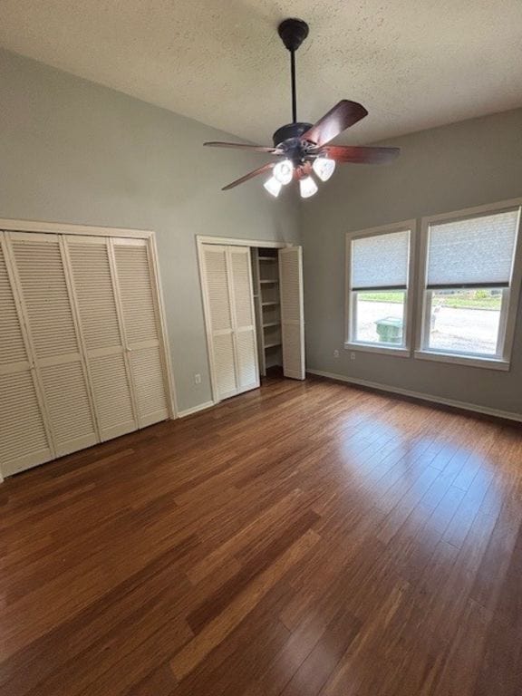 307 Quarry St, San Marcos, TX 78666 - unfurnished bedroom featuring wood finished floors, multiple closets, a textured ceiling, and a ceiling fan