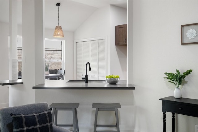 2012 Mimosa Trl, Round Rock, TX 78664 - kitchen featuring a sink, lofted ceiling, hanging light fixtures, dark countertops, and a breakfast bar area