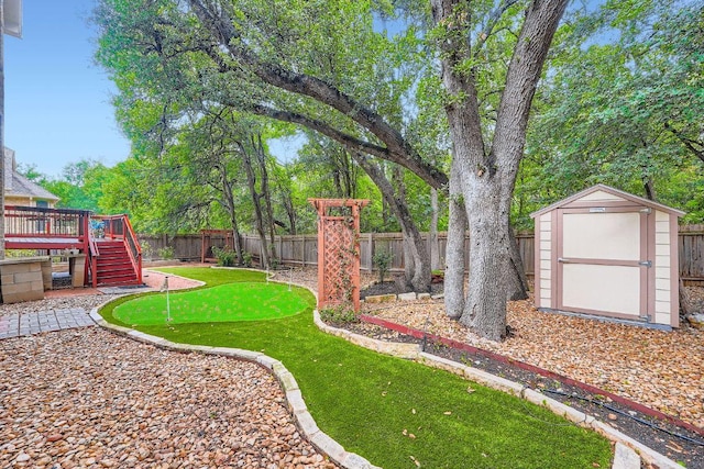 2607 Deep River Cir, Round Rock, TX 78665 - fenced backyard featuring a putting area, a shed, a deck, and stairs