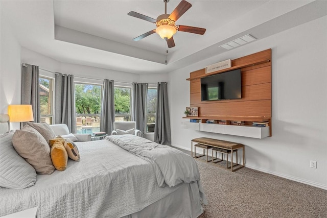 1626 Bearkat Canyon Dr, Dripping Springs, TX 78620 - carpeted bedroom featuring a raised ceiling, multiple windows, and a ceiling fan