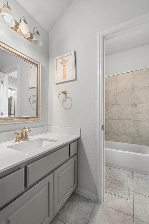 1626 Bearkat Canyon Dr, Dripping Springs, TX 78620 - bathroom featuring vanity, vaulted ceiling, and tile patterned floors