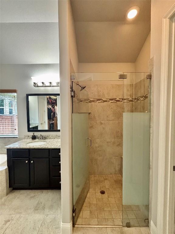 707 Mendocino Ln, Austin, TX 78737 - full bathroom featuring a shower stall, a bath, tile patterned flooring, vanity, and a walk in closet