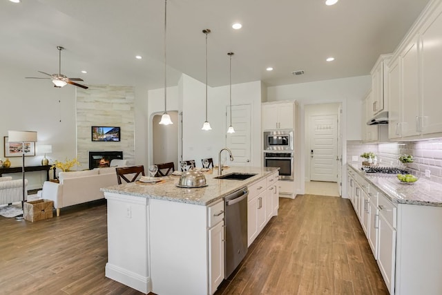 119 Loysoya St, Bastrop, TX 78602 - kitchen featuring a sink, appliances with stainless steel finishes, wood finished floors, ceiling fan, and white cabinets