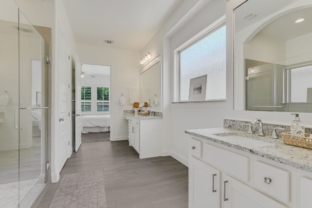 119 Loysoya St, Bastrop, TX 78602 - ensuite bathroom with a stall shower, two vanities, a ceiling fan, wood finished floors, and baseboards