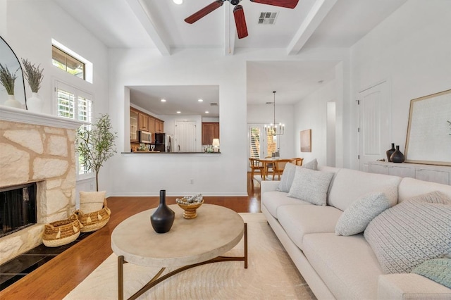 6201 River Place Blvd Unit 4, Austin, TX 78730 - living area featuring beam ceiling, light wood-style floors, ceiling fan, a chandelier, and a stone fireplace