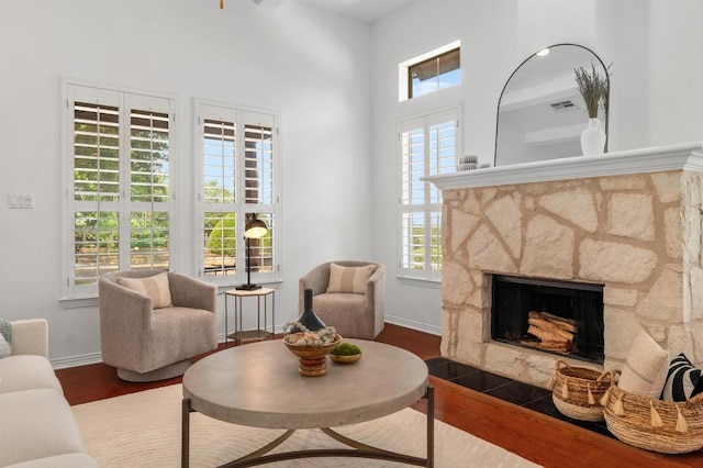 6201 River Place Blvd Unit 4, Austin, TX 78730 - living room featuring wood finished floors, a towering ceiling, and a stone fireplace