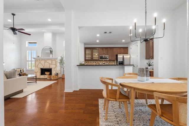 6201 River Place Blvd Unit 4, Austin, TX 78730 - dining area featuring dark wood-type flooring, a chandelier, ceiling fan, recessed lighting, and a stone fireplace