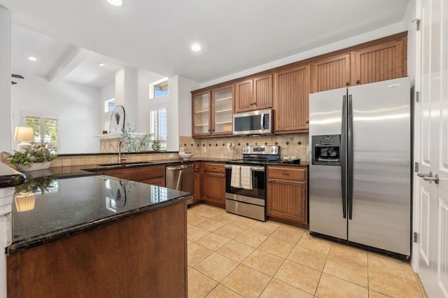 6201 River Place Blvd Unit 4, Austin, TX 78730 - kitchen with appliances with stainless steel finishes, tasteful backsplash, a peninsula, glass insert cabinets, and dark stone counters