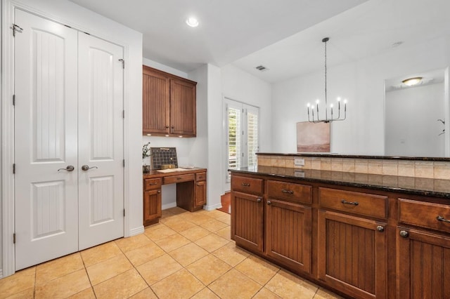 6201 River Place Blvd Unit 4, Austin, TX 78730 - kitchen featuring light tile patterned floors, built in desk, a chandelier, decorative light fixtures, and backsplash