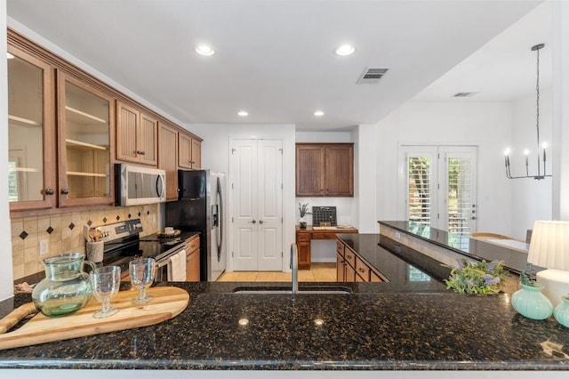 6201 River Place Blvd Unit 4, Austin, TX 78730 - kitchen with appliances with stainless steel finishes, recessed lighting, decorative backsplash, dark stone counters, and glass insert cabinets