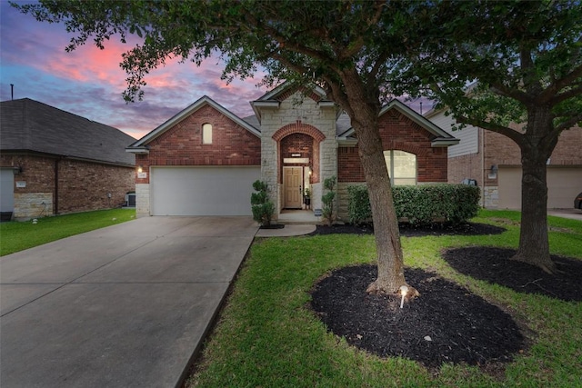 1017 Sussex Way, Round Rock, TX 78665 - traditional home featuring a garage, brick siding, concrete driveway, stone siding, and a lawn