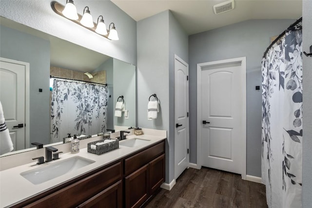 2612 American Dr, Lago Vista, TX 78645 - bathroom featuring wood finished floors, double vanity, curtained shower, and baseboards