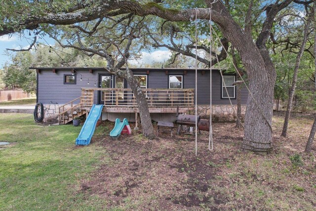 360 Little Barton Dr, Dripping Springs, TX 78620 - rear view of house featuring a wooden deck, a lawn, and a playground