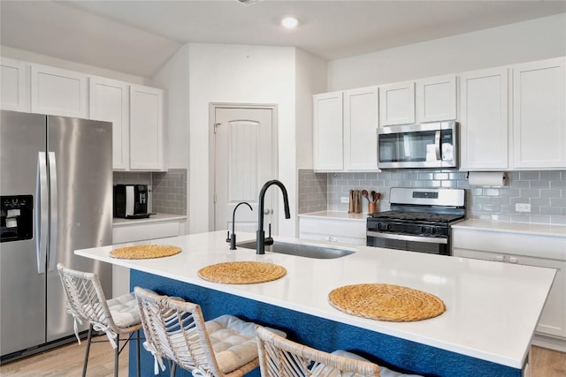 225 Sweetwater Creek Ln, Hutto, TX 78634 - kitchen featuring appliances with stainless steel finishes, a sink, a center island with sink, and light countertops