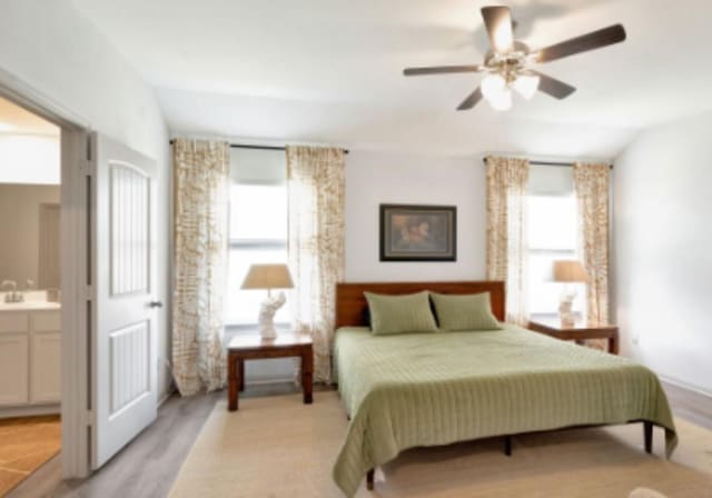 225 Sweetwater Creek Ln, Hutto, TX 78634 - bedroom with a sink, ensuite bath, light wood finished floors, and a ceiling fan