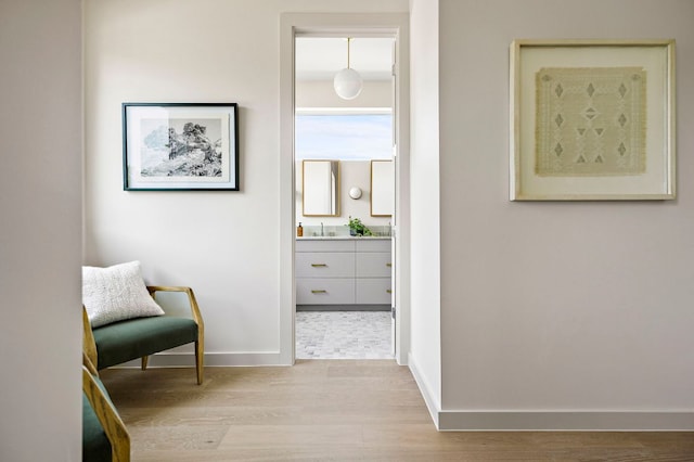 2403 E 22nd St, Austin, TX 78722 - hallway featuring light wood-style floors, baseboards, and a sink