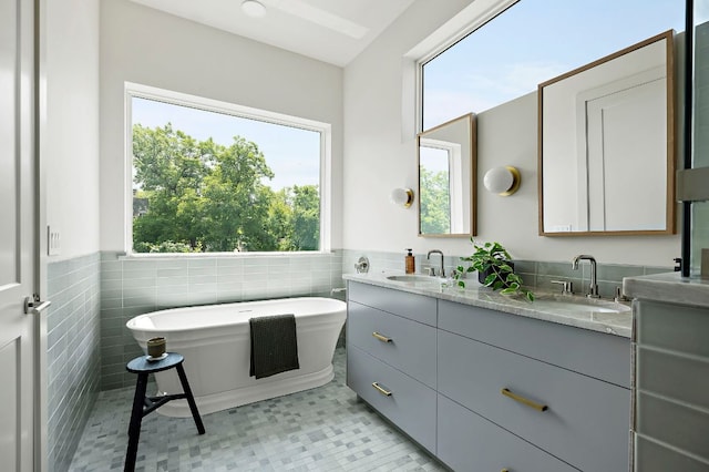 2403 E 22nd St, Austin, TX 78722 - bathroom featuring double vanity, a freestanding tub, a wainscoted wall, and tile walls