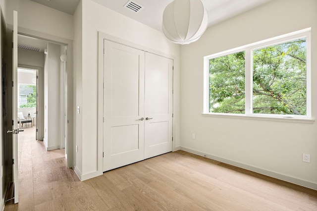 2403 E 22nd St, Austin, TX 78722 - unfurnished bedroom with light wood-type flooring, baseboards, and a closet