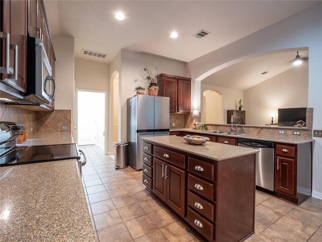 2214 Yellow Bird Trl, Austin, TX 78734 - kitchen with appliances with stainless steel finishes, arched walkways, a center island, backsplash, and recessed lighting