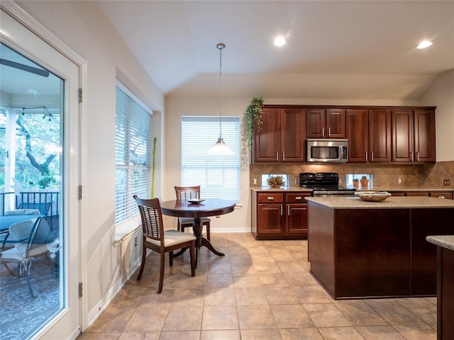 2214 Yellow Bird Trl, Austin, TX 78734 - kitchen with stainless steel microwave, black electric range, lofted ceiling, backsplash, and pendant lighting