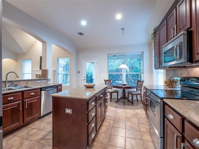 2214 Yellow Bird Trl, Austin, TX 78734 - kitchen with appliances with stainless steel finishes, a sink, decorative backsplash, vaulted ceiling, and decorative light fixtures