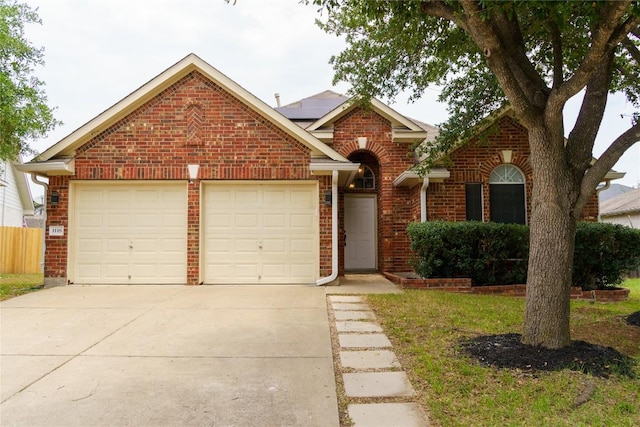 1118 Connemara Ln, Pflugerville, TX 78660 - traditional-style house featuring brick siding, an attached garage, concrete driveway, and roof mounted solar panels