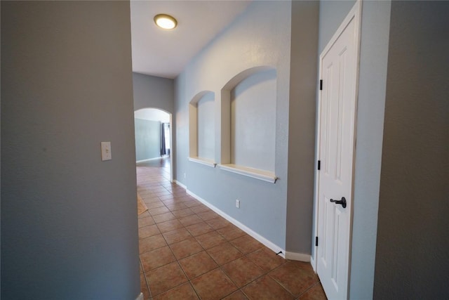 1118 Connemara Ln, Pflugerville, TX 78660 - hallway with dark tile patterned floors, arched walkways, and baseboards
