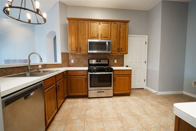 1118 Connemara Ln, Pflugerville, TX 78660 - kitchen featuring stainless steel appliances, brown cabinets, and backsplash