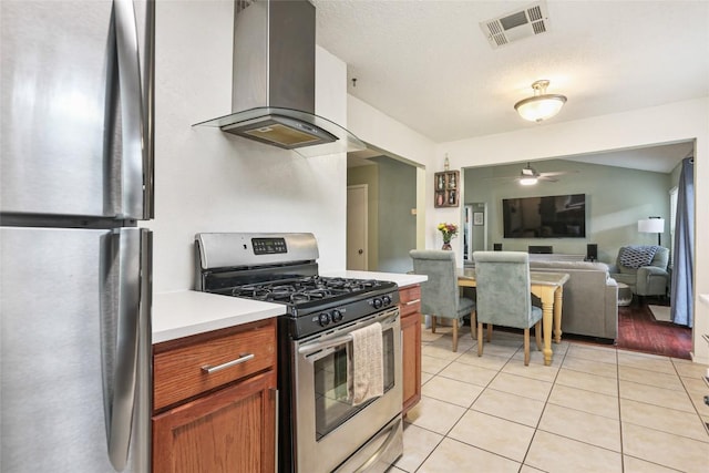 12320 Cedarspur Rd, Austin, TX 78758 - kitchen featuring appliances with stainless steel finishes, island range hood, ceiling fan, light countertops, and light tile patterned flooring