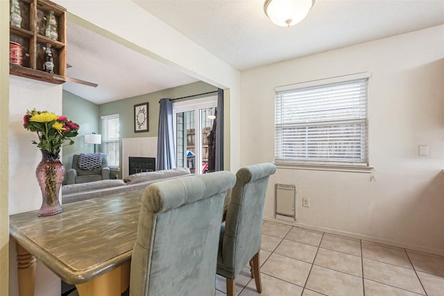 12320 Cedarspur Rd, Austin, TX 78758 - dining room featuring light tile patterned floors, baseboards, a fireplace, and ceiling fan
