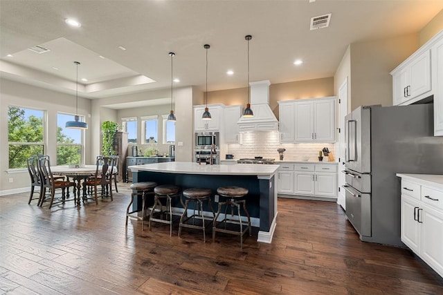 403 Baldovino Skwy, Austin, TX 78738 - kitchen with appliances with stainless steel finishes, premium range hood, light countertops, backsplash, and white cabinetry