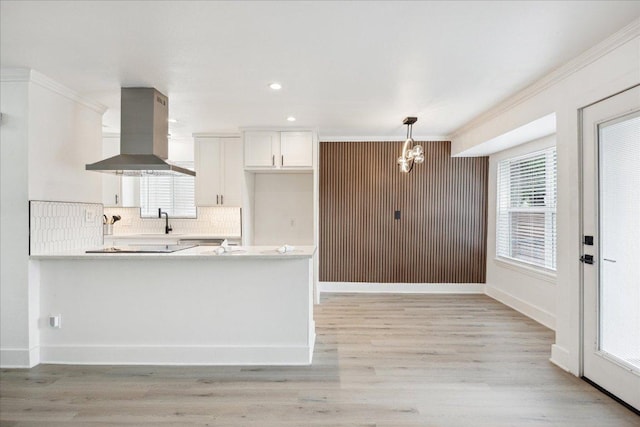 6102 Amber Pass, Austin, TX 78745 - kitchen with island exhaust hood, crown molding, white cabinets, light countertops, and a chandelier