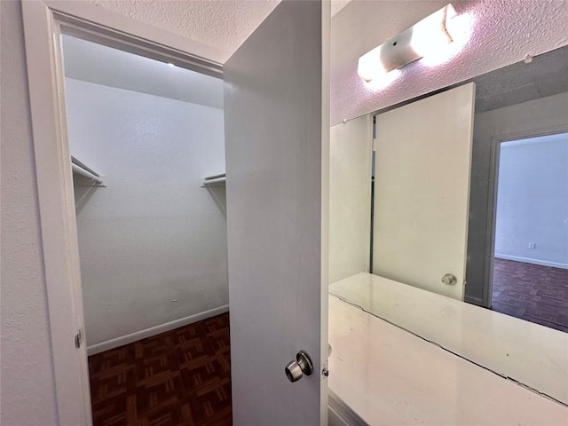 5005 S Pleasant Valley Rd, Austin, TX 78744 - bathroom with a textured ceiling, baseboards, and a spacious closet