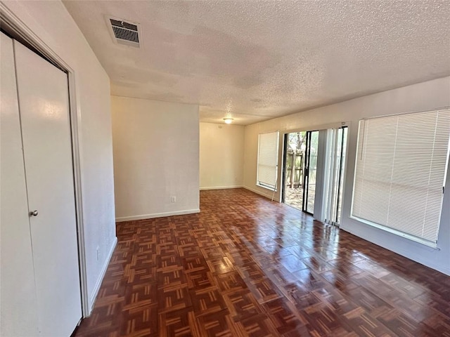 5005 S Pleasant Valley Rd, Austin, TX 78744 - spare room featuring a textured ceiling and baseboards