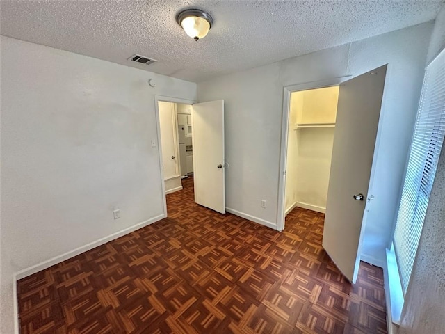5005 S Pleasant Valley Rd, Austin, TX 78744 - unfurnished bedroom featuring a textured ceiling and baseboards
