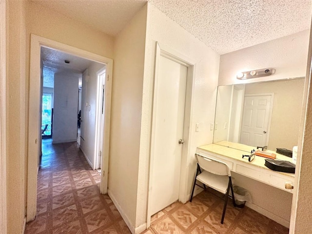 5005 S Pleasant Valley Rd, Austin, TX 78744 - hall featuring a textured ceiling, an office area, and light floors