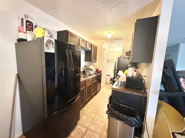 7106 Astro View Dr, Austin, TX 78724 - kitchen with freestanding refrigerator, a textured ceiling, and light floors