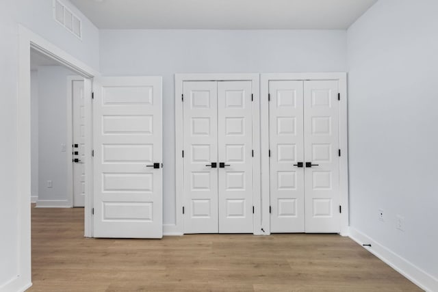 2500 Longview St Unit 101, Austin, TX 78705 - unfurnished bedroom with two closets, light wood-style flooring, and baseboards