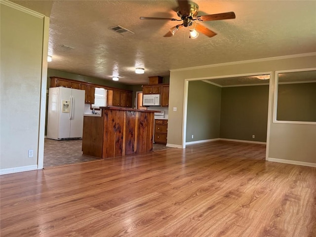 429 Camelback Rd, La Grange, TX 78945 - kitchen with white appliances, open floor plan, light wood-style flooring, a textured ceiling, and ornamental molding
