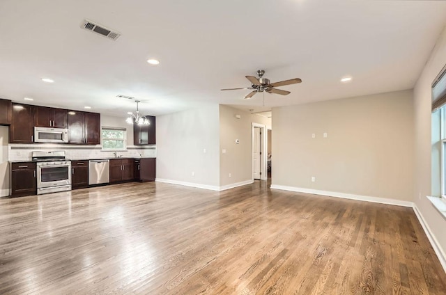 704 Wren Ave, Austin, TX 78753 - unfurnished living room with a chandelier, recessed lighting, a ceiling fan, and light wood-type flooring