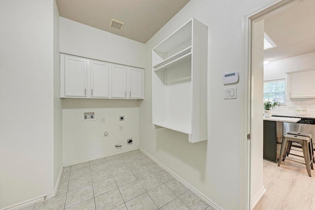2701 Bolton St, Austin, TX 78748 - laundry area with cabinet space, gas dryer hookup, hookup for an electric dryer, washer hookup, and baseboards